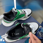 Side view of white and green lace-up sneakers with black sock liner and Dior insole