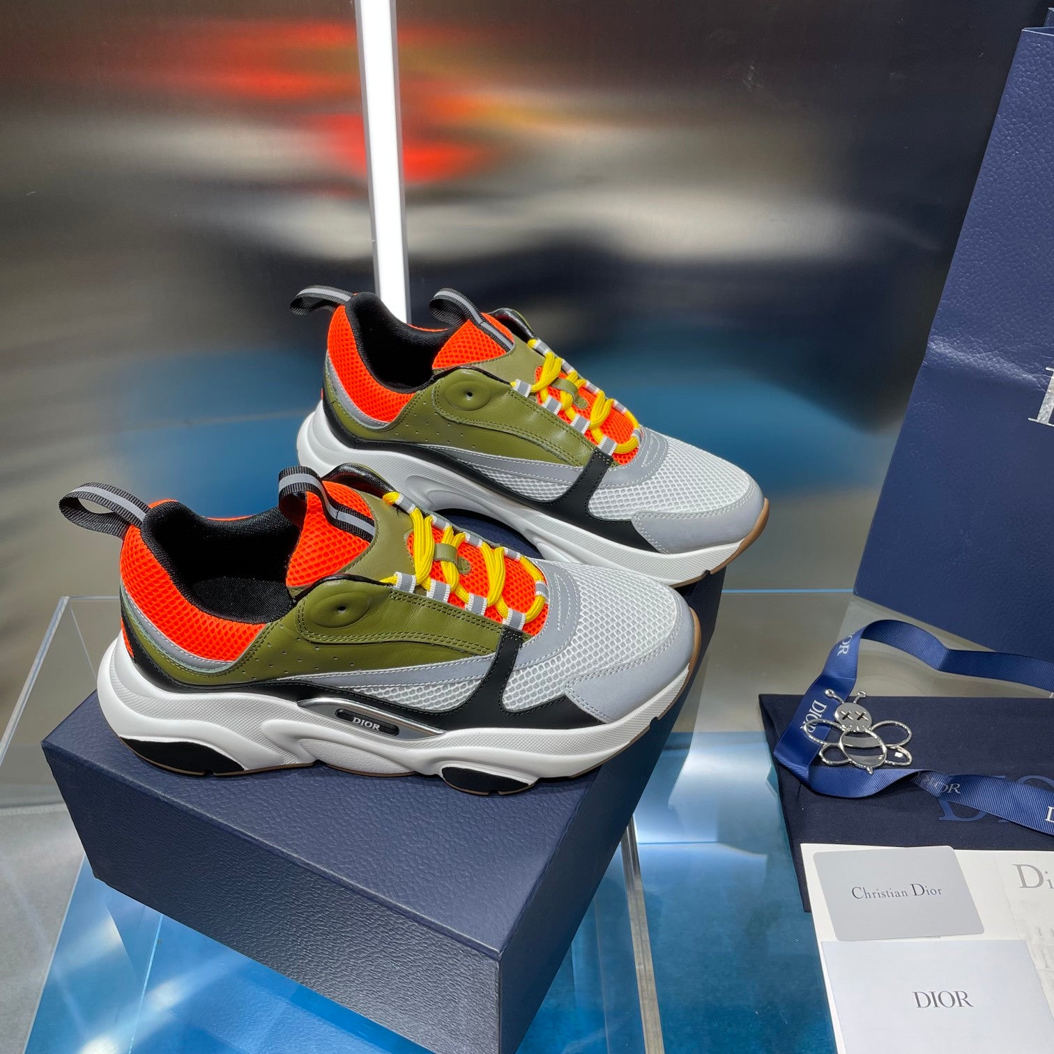 Dior unisex sneakers pair: white, olive and orange color block with multicolor lace-up