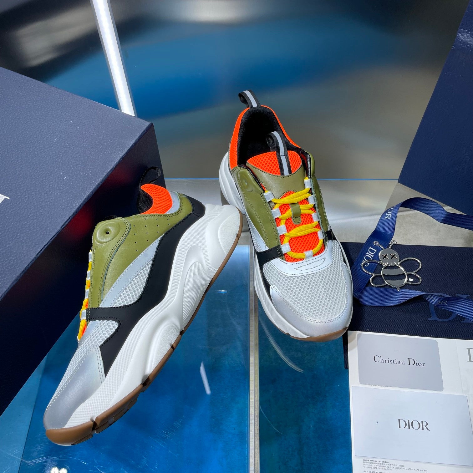 Dior unisex low-top sneakers, olive and white panels with orange trim and braided laces