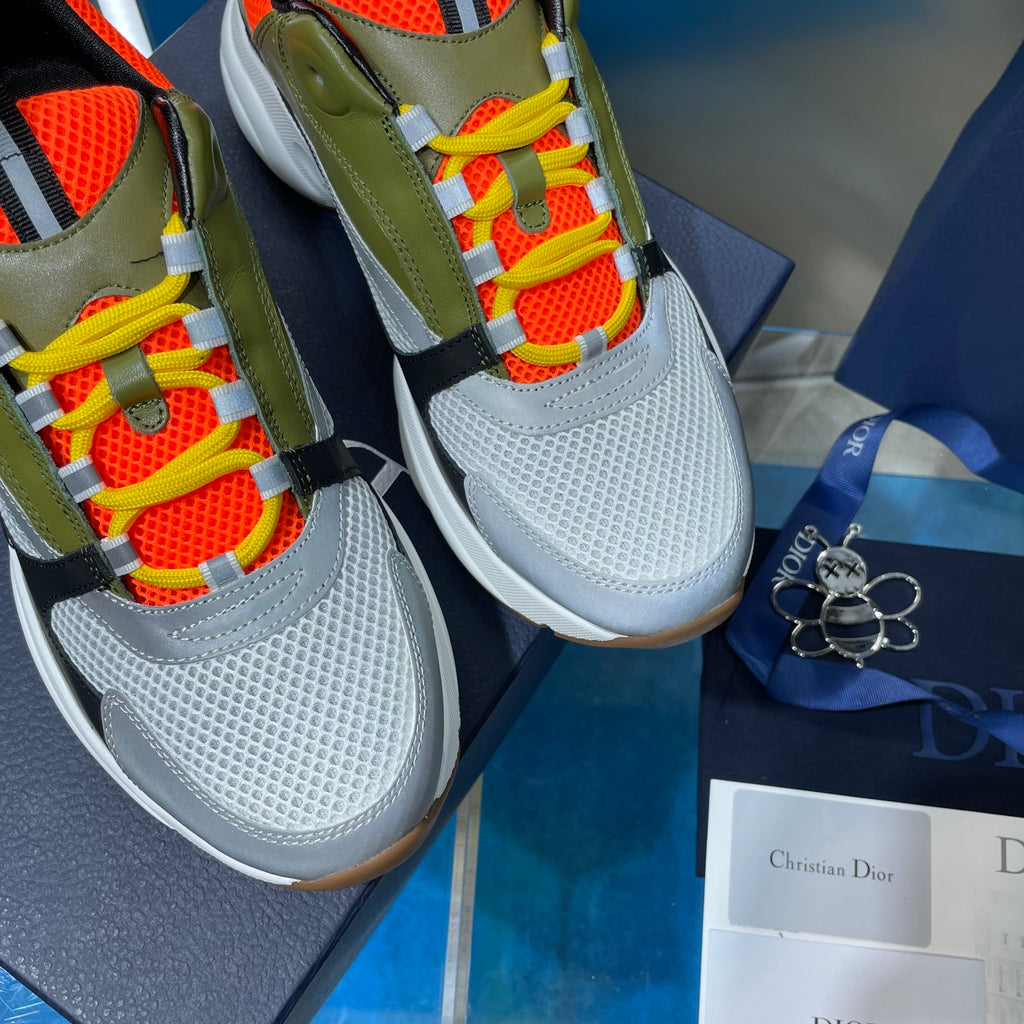 Dior unisex sneakers close-up: olive upper with orange mesh, multicolor lace-up detail