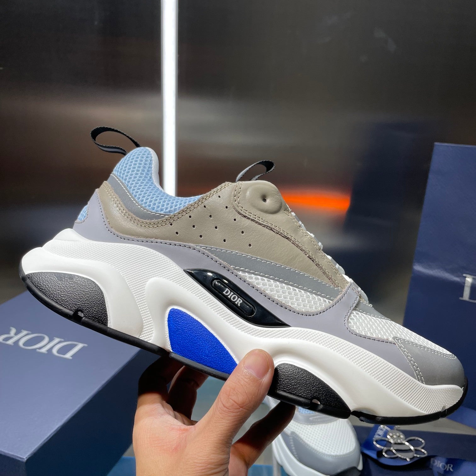 Unisex sneaker with light blue mesh upper, beige details, and blue stripe