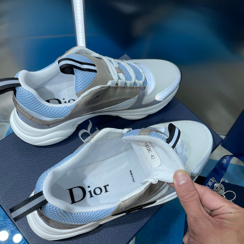 Unisex sneakers with light blue uppers and beige overlays, one shoe lifted