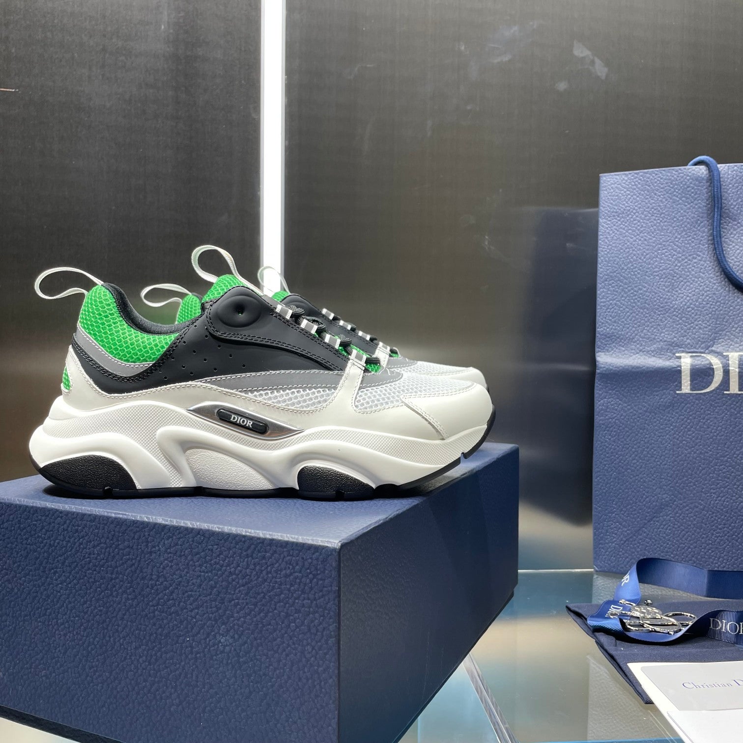 Dior unisex sneakers on box, white upper with black toe and green-striped laces
