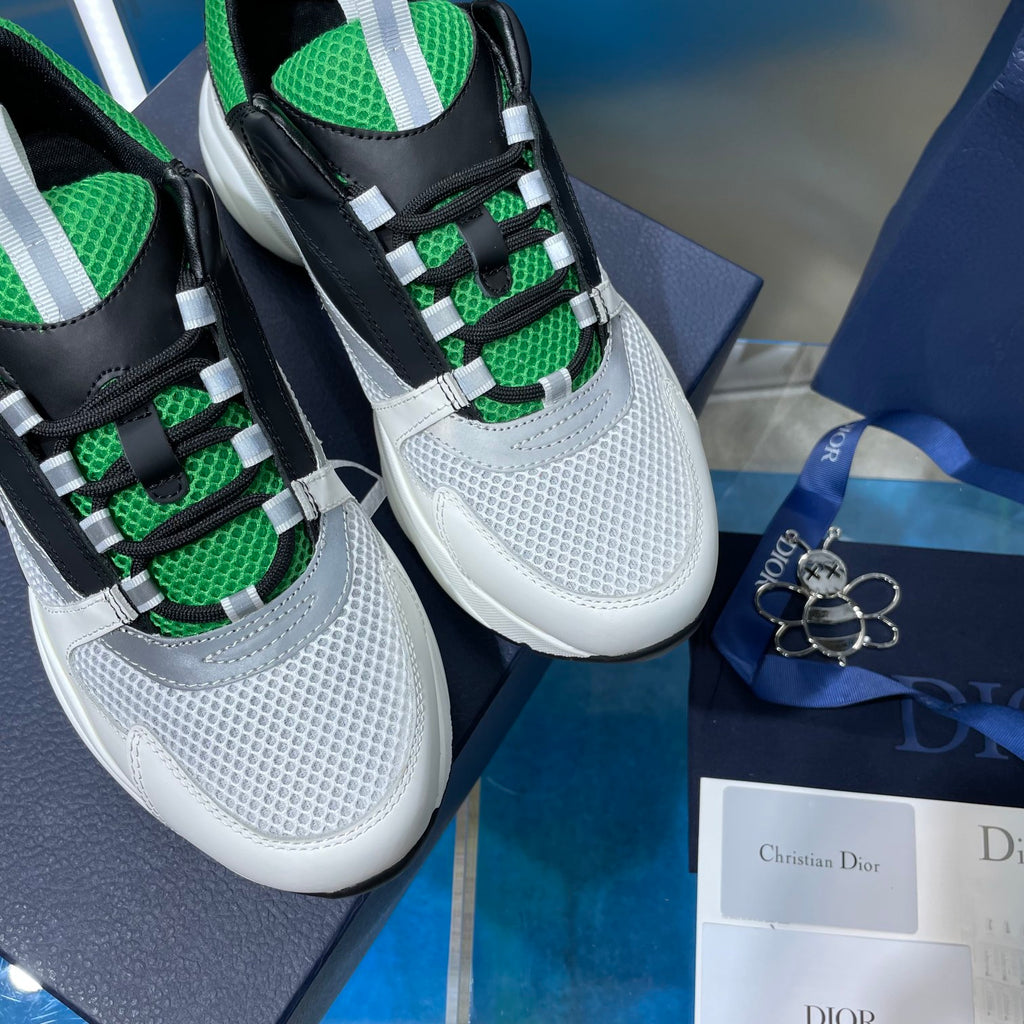 Unisex Dior sneakers close-up, white mesh with black tongue and green lace pattern
