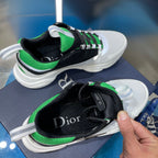 Unisex Dior sneakers close-up, hand holding black tongue; green collar and laces