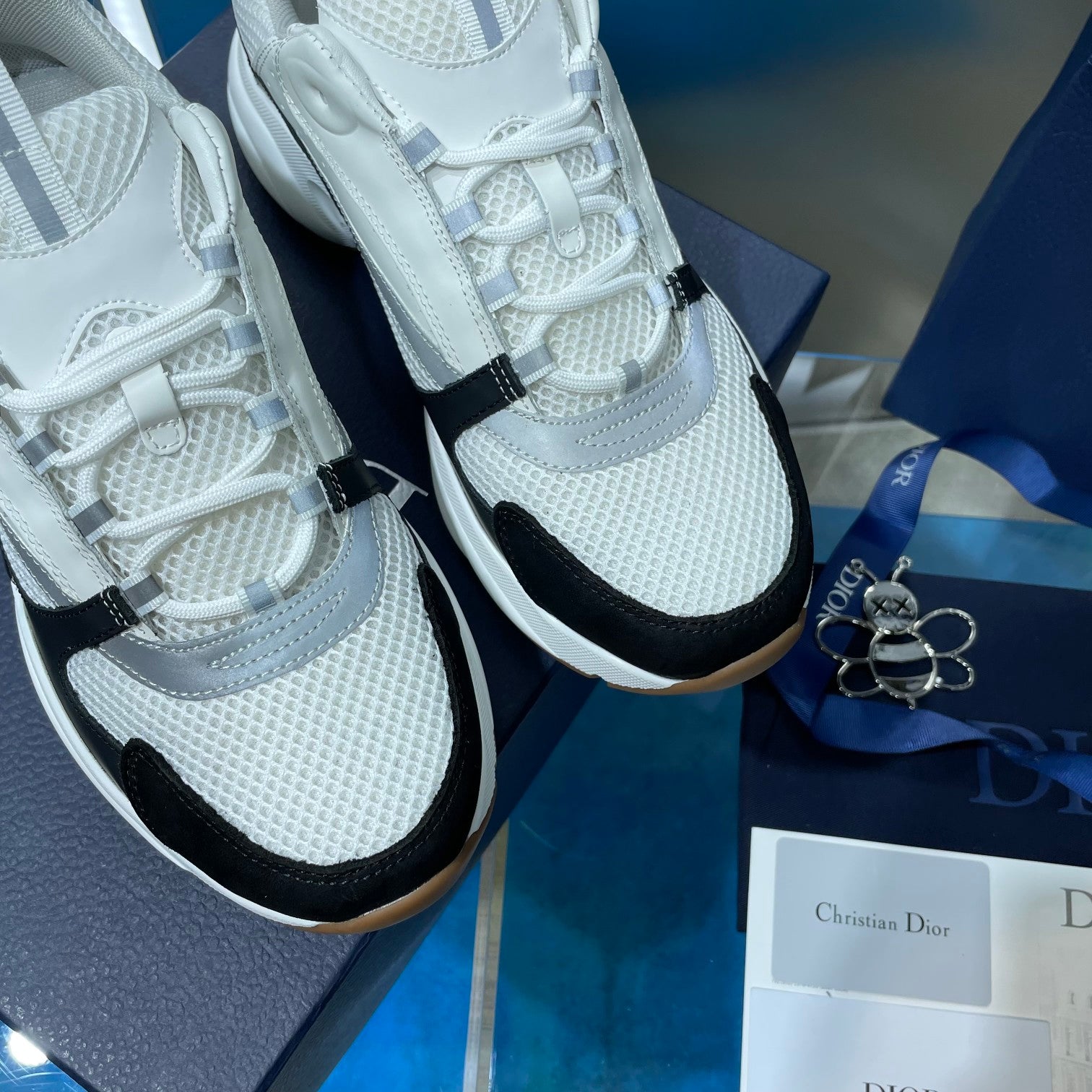 Unisex Dior sneakers close-up, white laces and mesh knit with black side accent