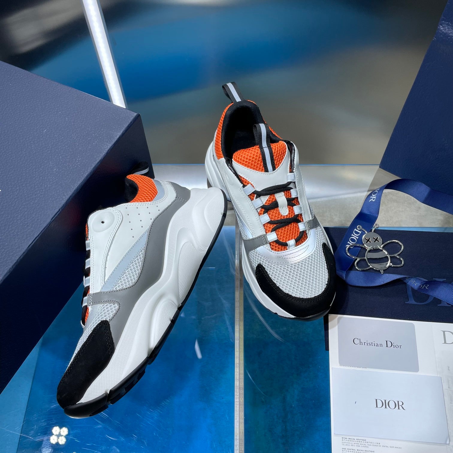 Dior unisex sneakers with white sole and upper, orange-and-black accents, lace-up.
