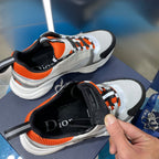 Dior unisex sneakers top view, white mesh with orange laces and black interior strap.