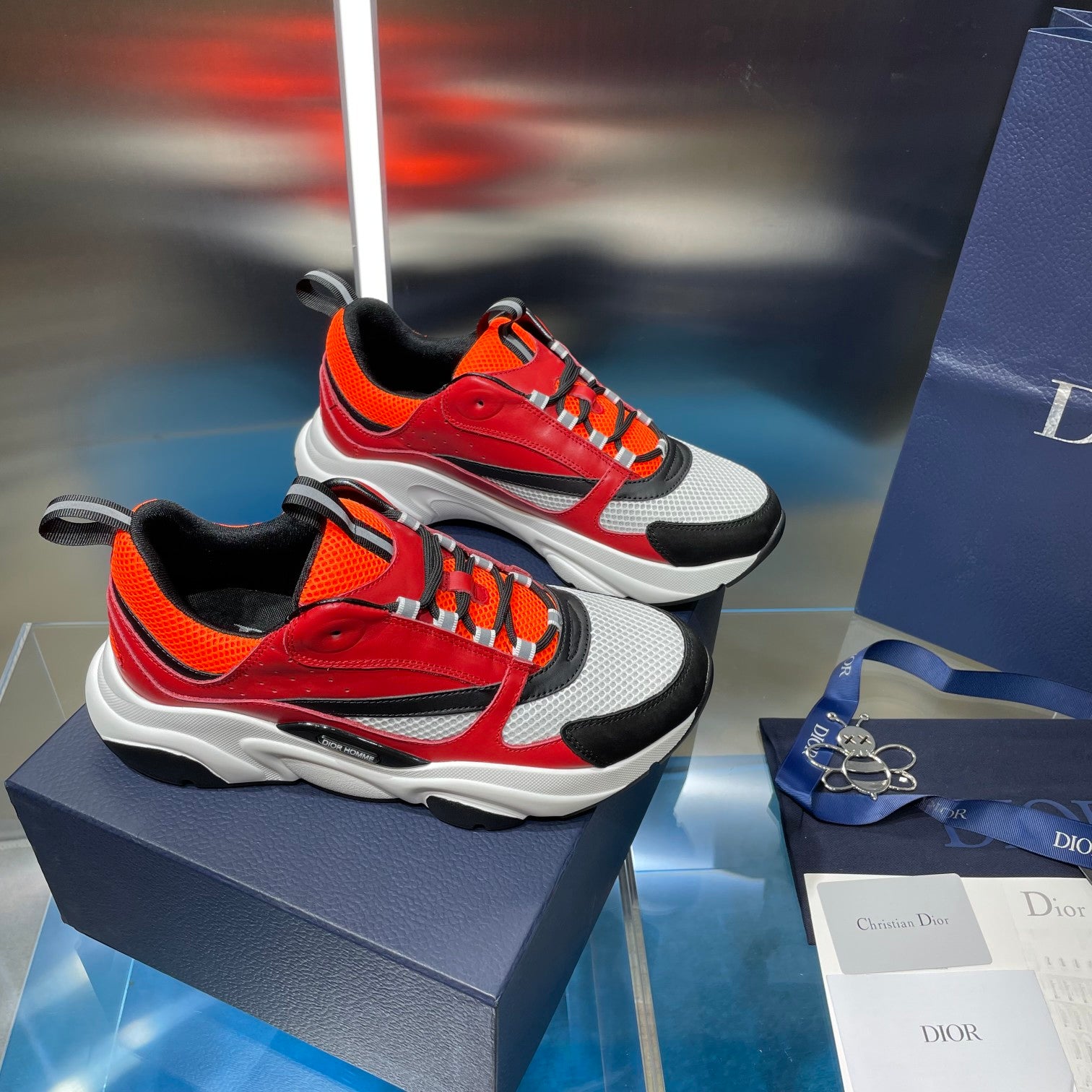 Dior chunky sneakers pair with red and orange uppers, black toe and white sole