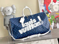 Men's blue monogram duffel bag with top handles and white strap accent