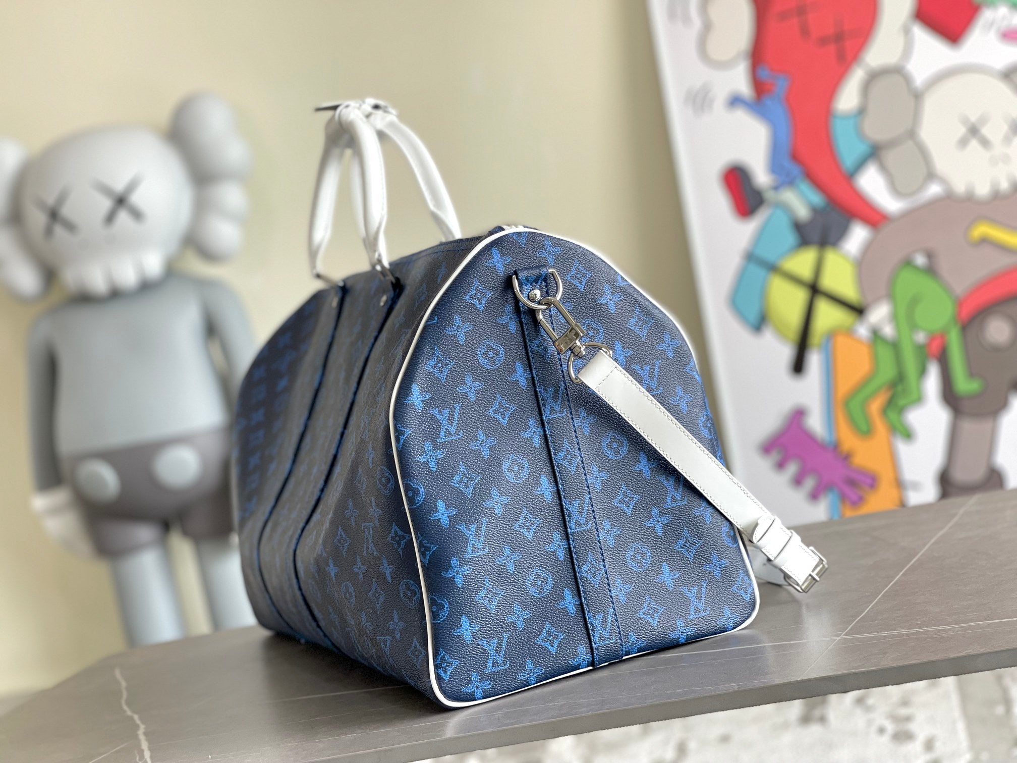 Blue monogram duffel bag with zipper, shoulder strap, and silver hardware