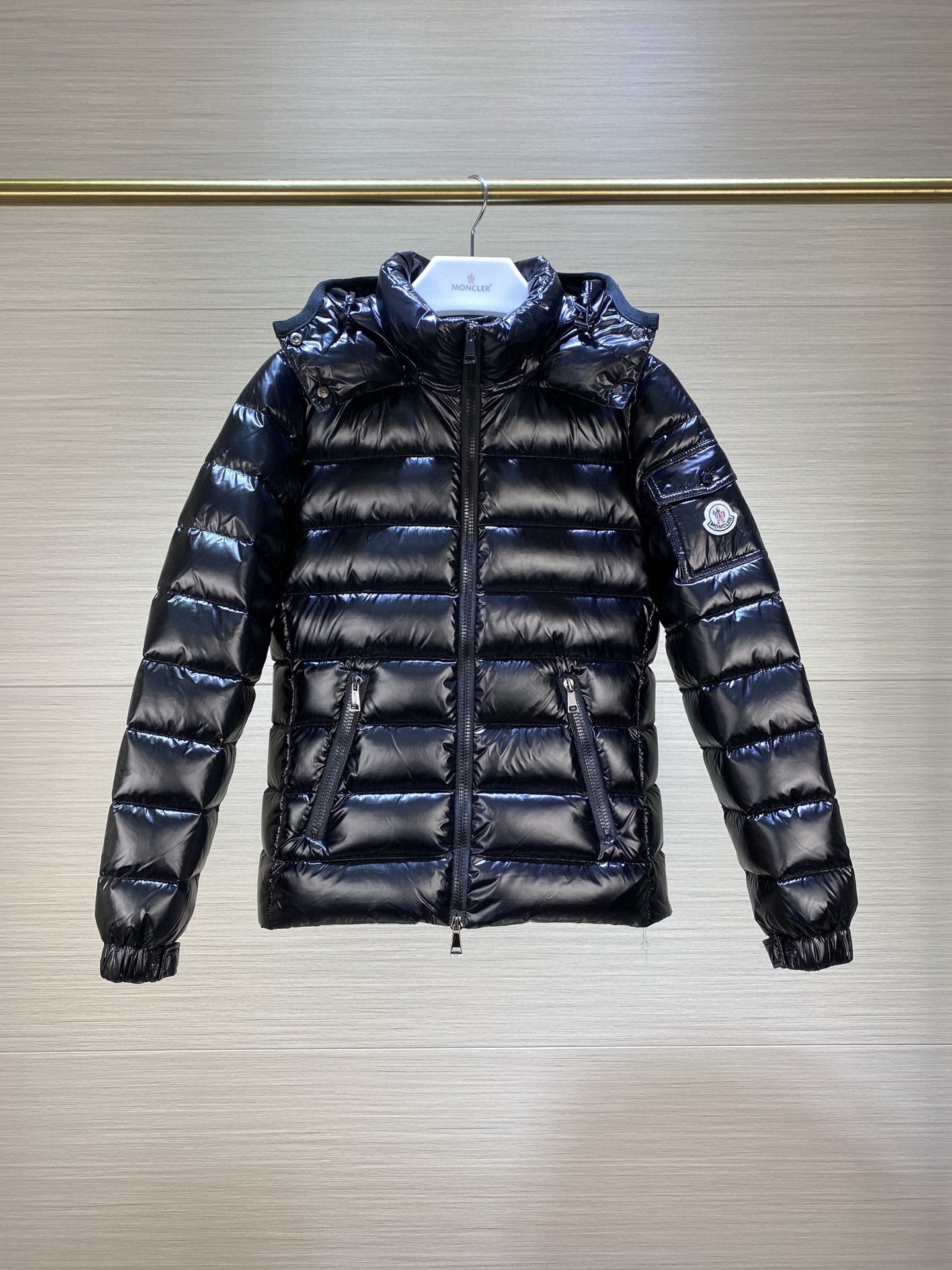 Dark puffer jacket with hood, full-zip front, quilted panels and long sleeves