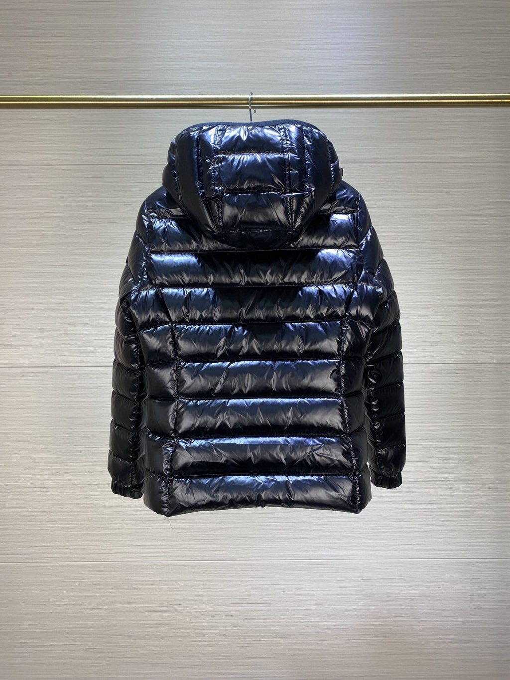 Dark puffer jacket with hood, quilted back paneling and long sleeves