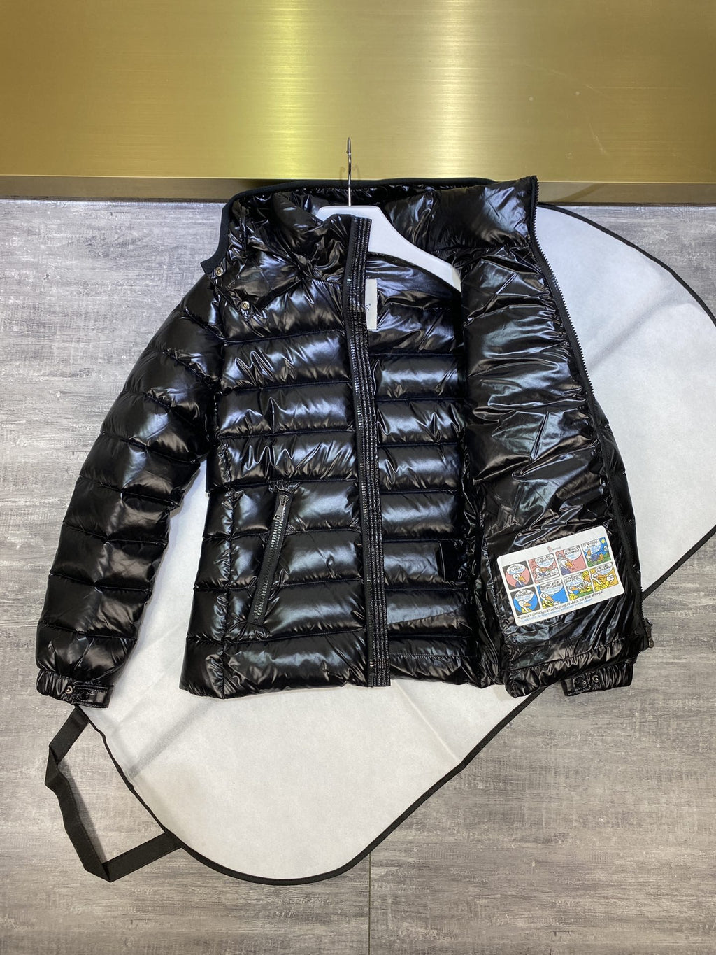 Dark puffer jacket with hood, full-zip front, quilted panels and side label