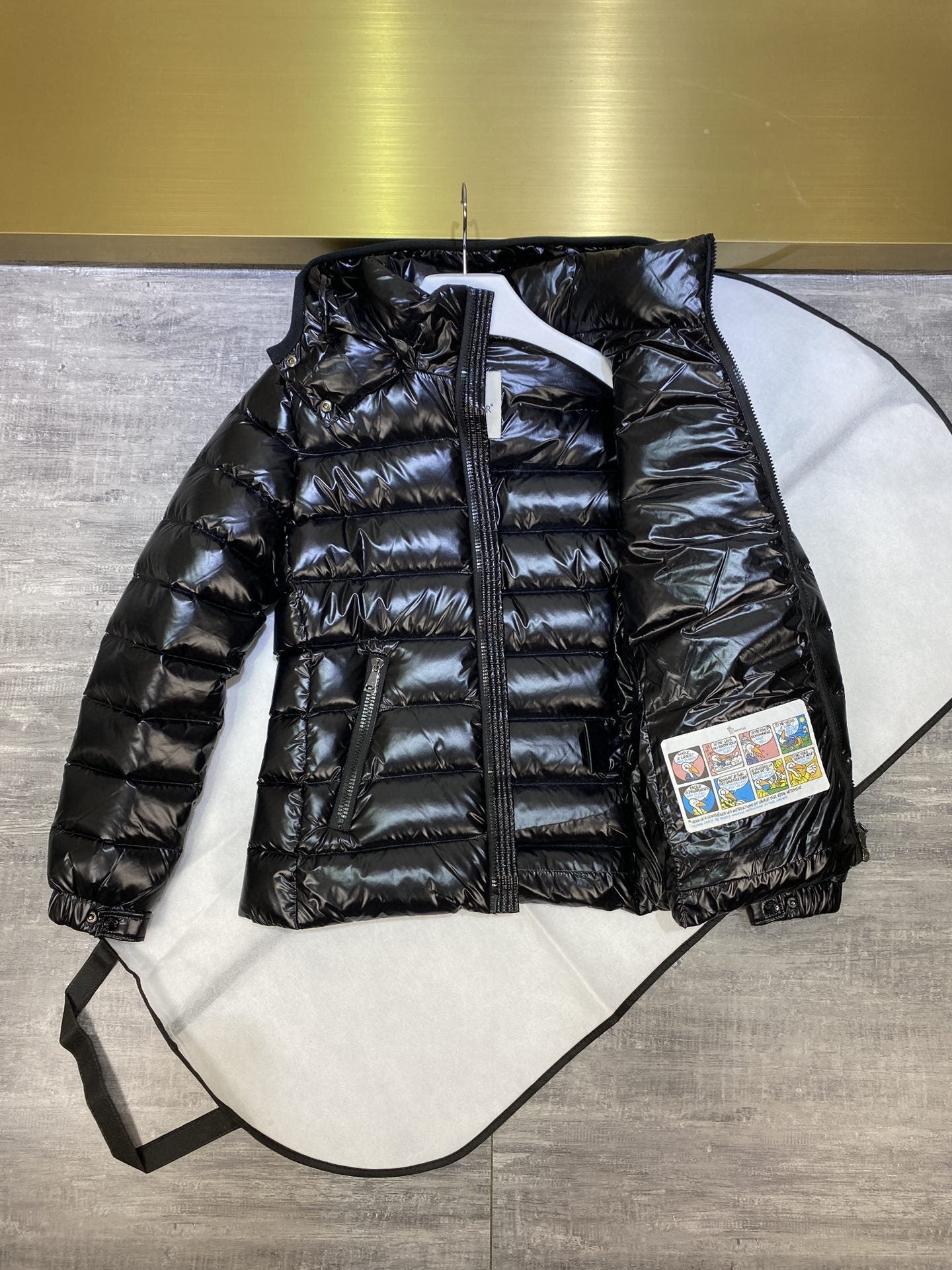 Dark puffer jacket with hood, full-zip front, quilted panels and side label
