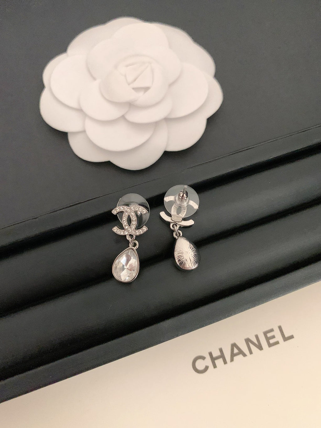 Silver-tone drop earrings with teardrop crystal charms and tassel detail