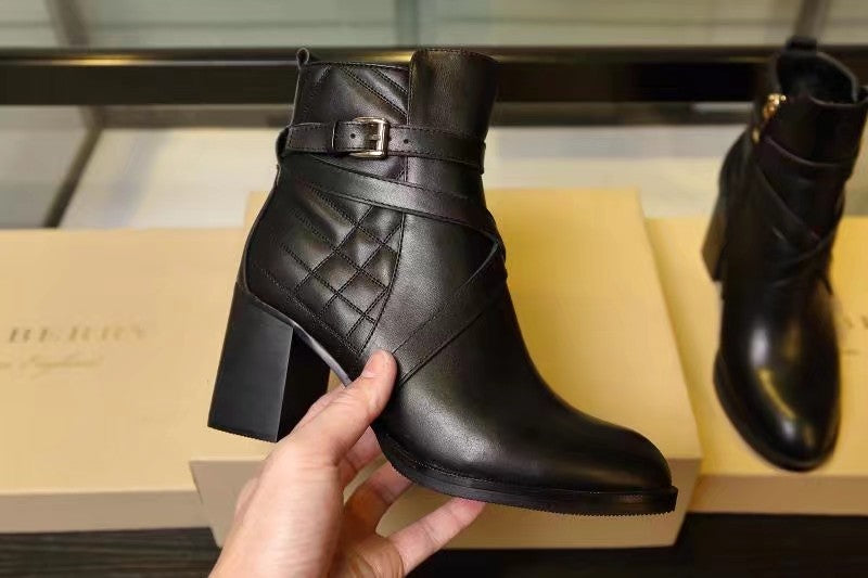 Black leather ankle boots with quilted panels and buckle strap