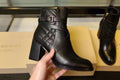 Black leather ankle boots with quilted panels and buckle strap