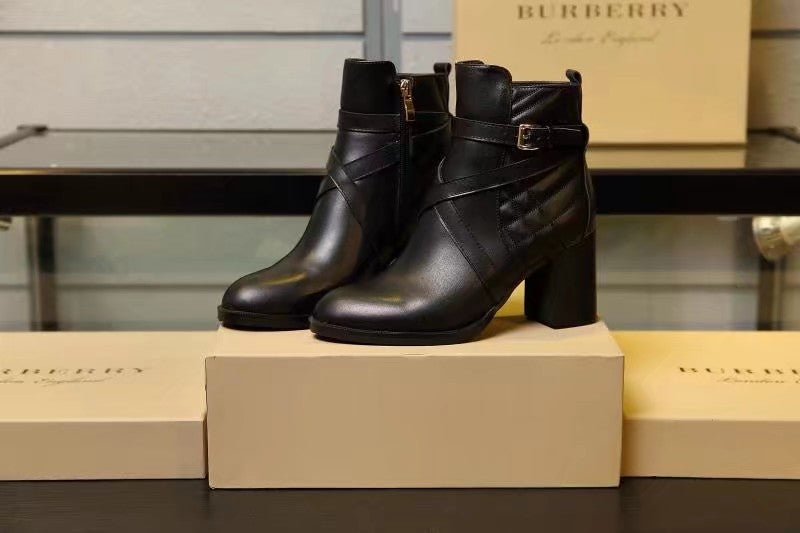 Pair of black leather ankle boots on a box with stacked block heel