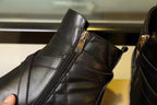 Black leather ankle boot with zipper and buckle strap close-up