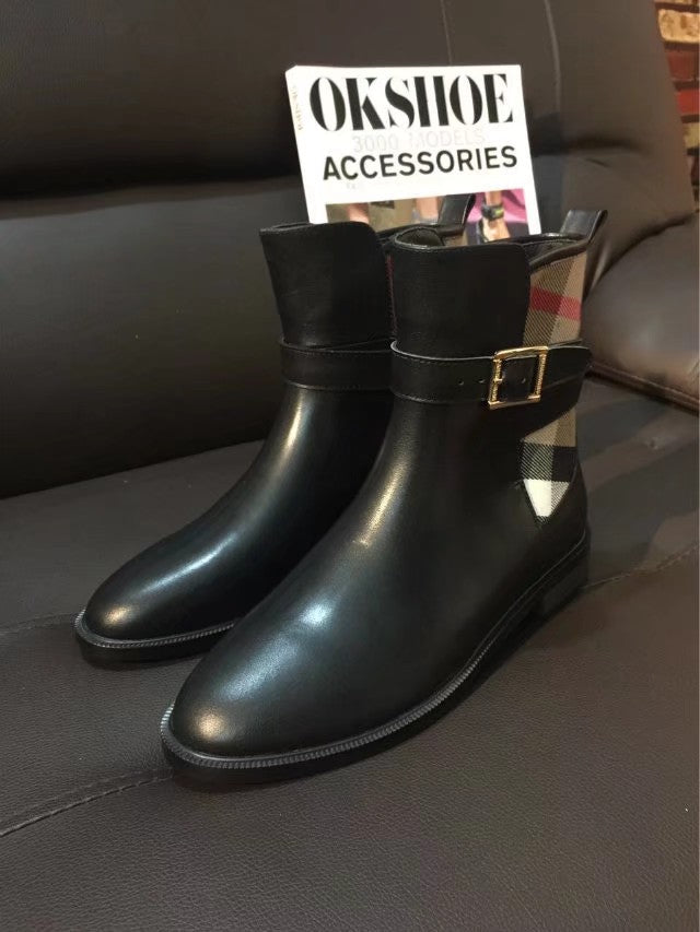 Black leather tall boots with gold-tone buckle accents and stitched sole edge