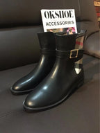 Black leather tall boots with gold-tone buckle accents and stitched sole edge