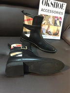 Black leather ankle boots with gold-tone buckle strap and plaid lining detail