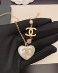 Gold-tone chain necklace with heart pendant, pink bead, Chanel logo charm