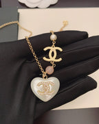 Gold-tone chain necklace with heart pendant, pink bead, Chanel logo charm