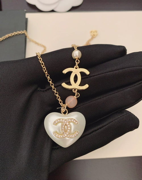Gold-tone chain necklace with heart pendant, pink bead, Chanel logo charm
