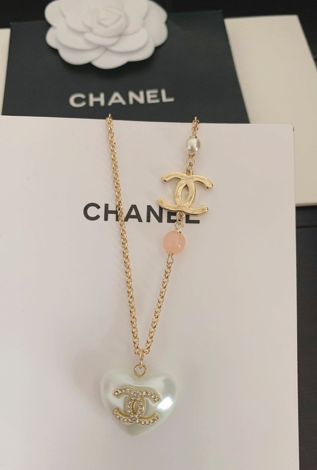 Gold-tone heart pendant necklace with pink bead and Chanel logo charm