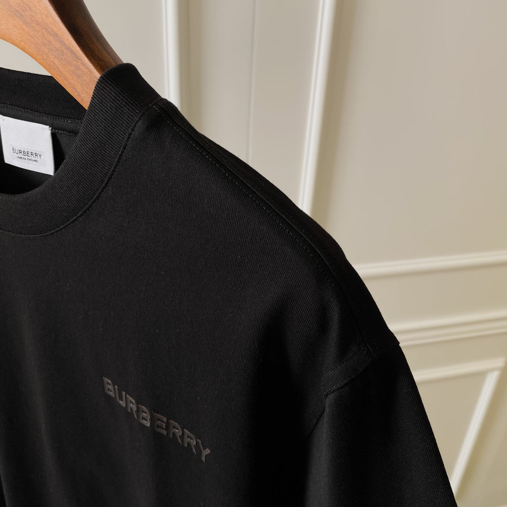 Black T-shirt neckline with small fabric tag and embroidered-style BURBERRY logo