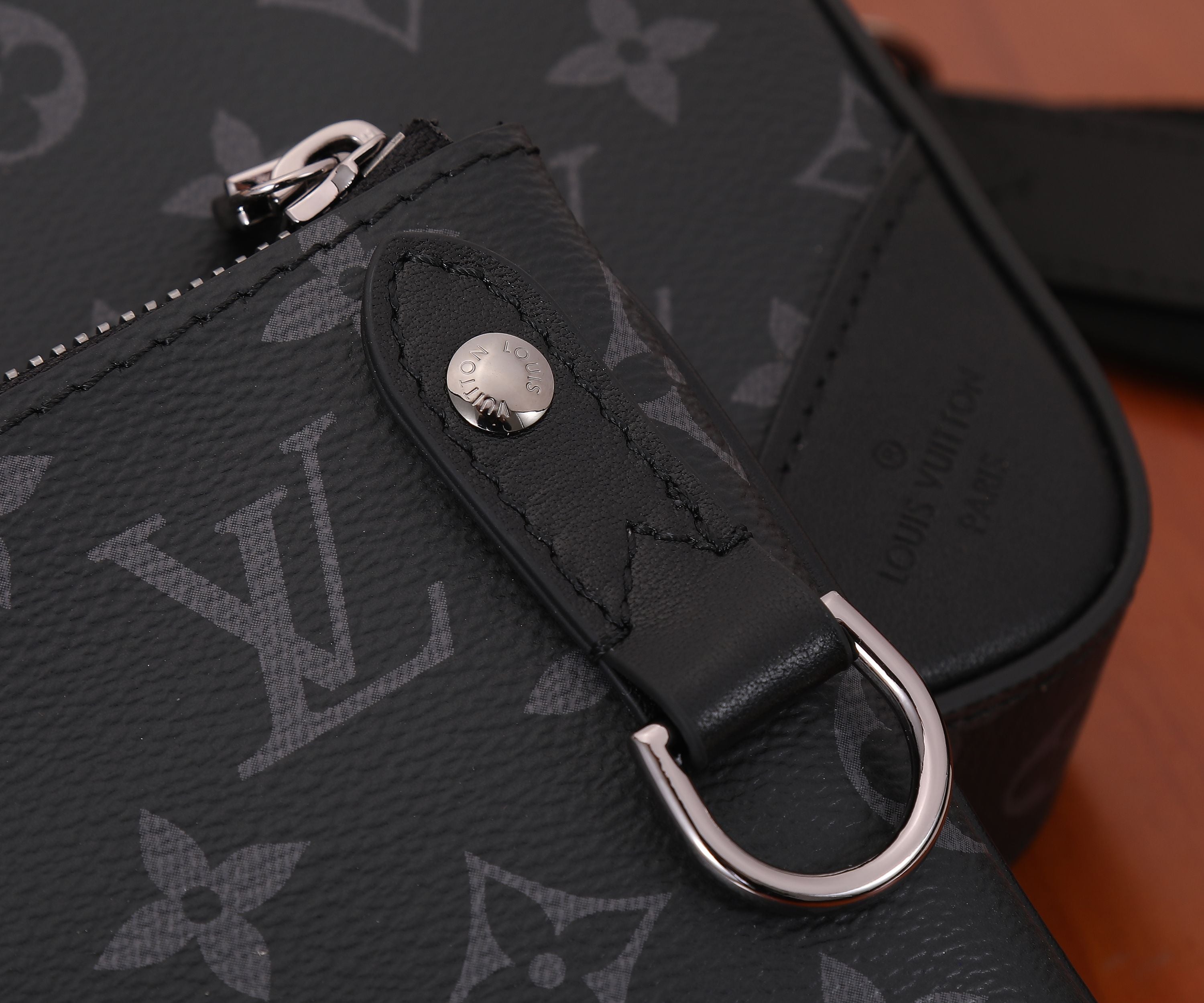 Louis Vuitton bag side strap ring on dark monogram canvas with stitched detail