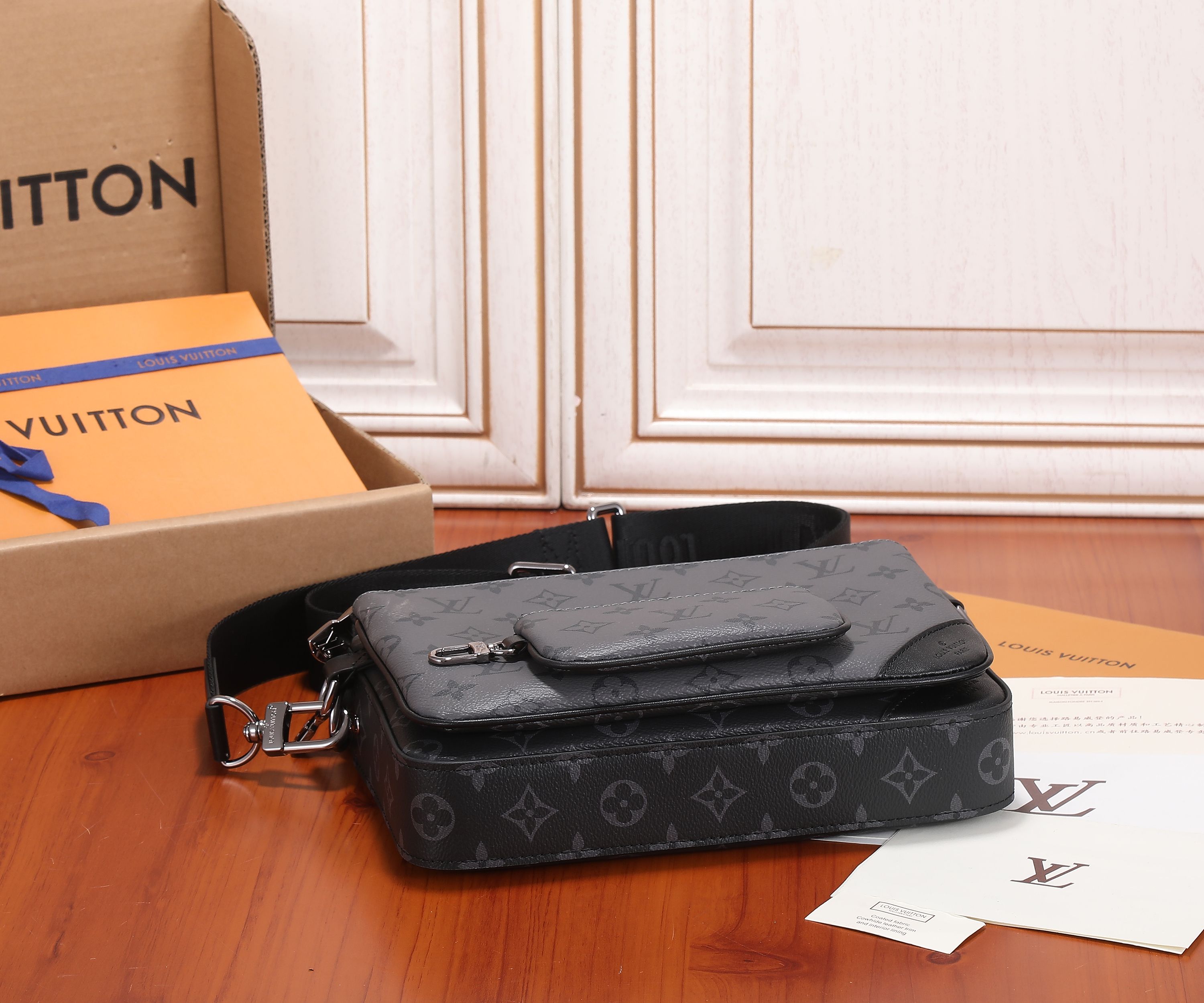 Louis Vuitton men's crossbody bag with dark monogram canvas, front pocket, and strap