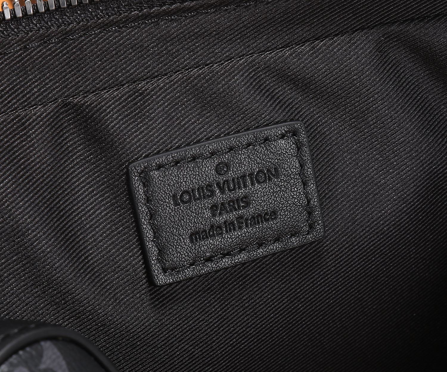 Louis Vuitton bag label on dark lining with printed brand and origin text