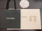 Gold-tone hoop earrings with pearl bead drops, shown with branded gift boxes