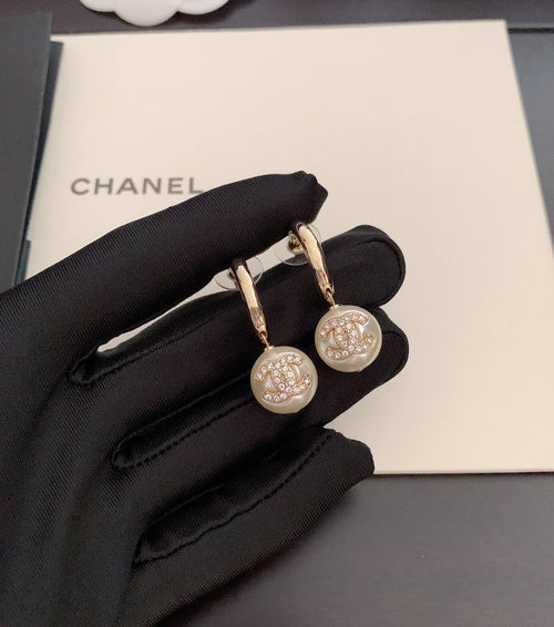 Gold-tone hoop earrings with round crystal charm and small pearl drop