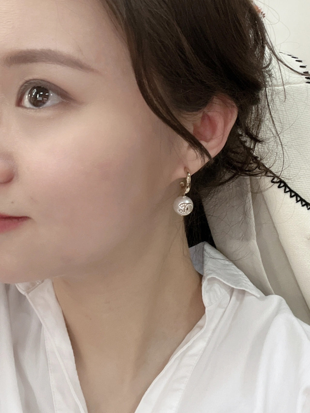 Gold-tone earrings with pearl drops worn by model
