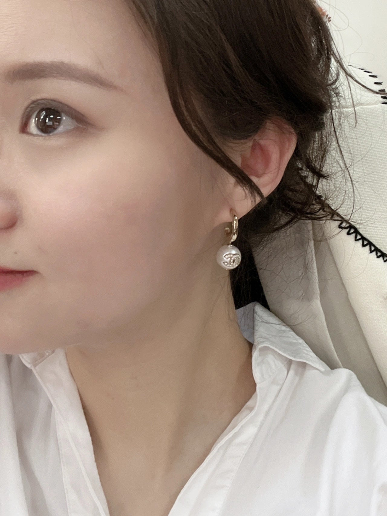 Gold-tone earrings with pearl drops worn by model