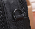 Black leather crossbody bag zipper pull with fabric tab and stitched edging