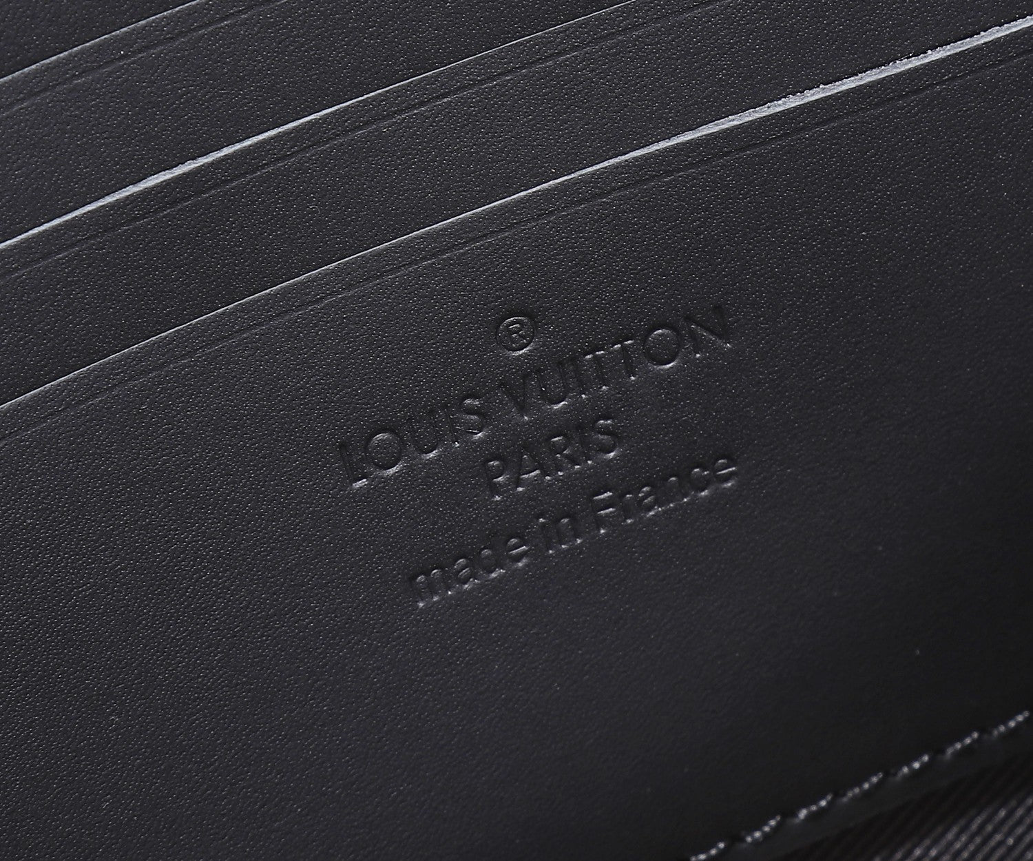 Black leather crossbody bag with debossed logo and branding on base panel