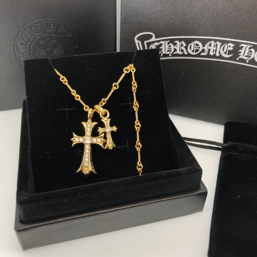 Gold cross pendant necklace with chain on black jewelry box