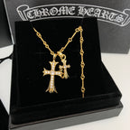 Gold cross pendant necklace with dangling chain on black box