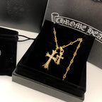 Gold cross pendant necklace with layered chain on black jewelry box