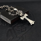 Silver-tone cross pendant on chain with small engraved details