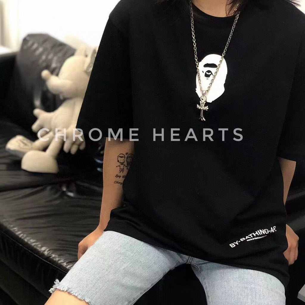 Silver-tone cross pendant necklace worn with black graphic T-shirt
