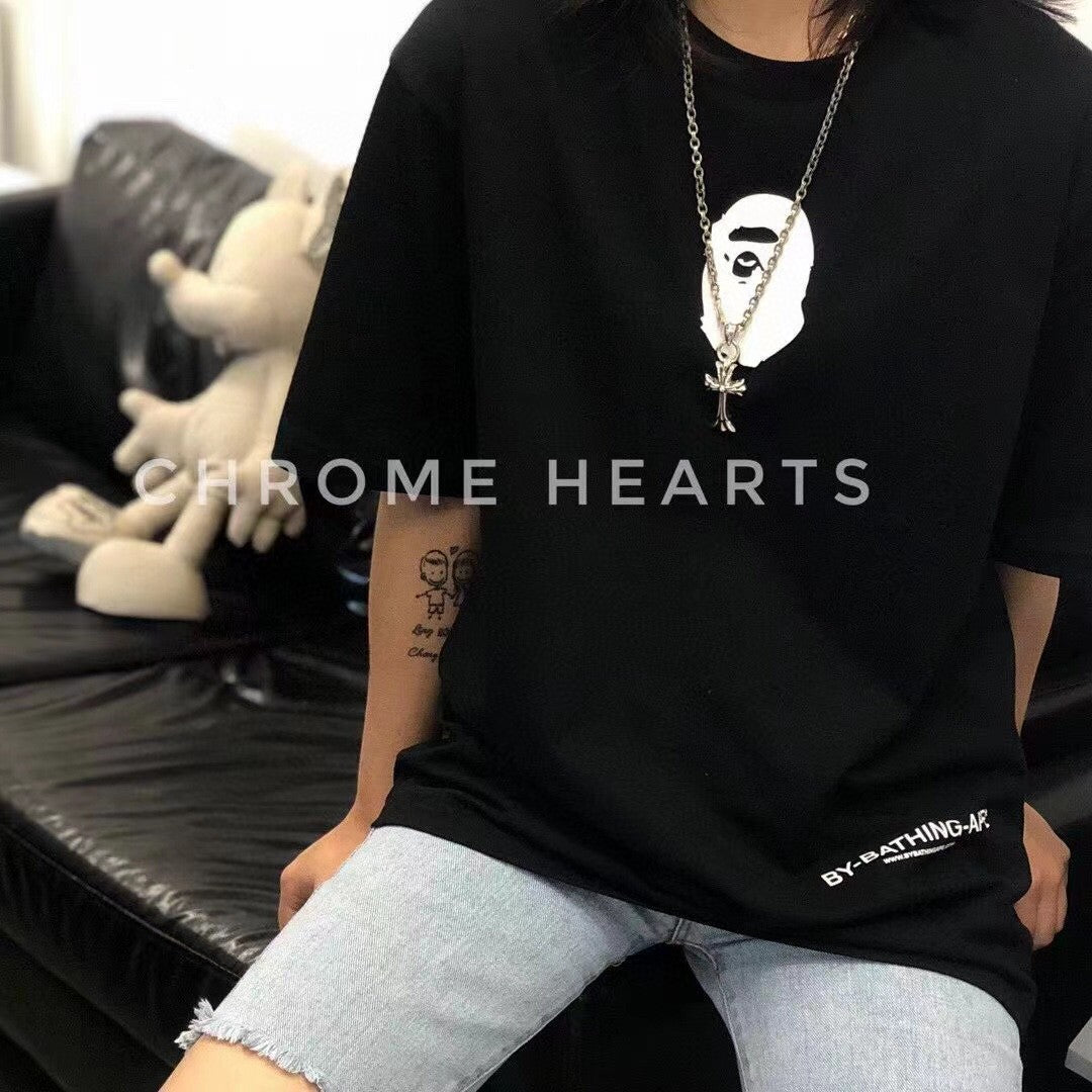 Silver-tone cross pendant necklace worn with black graphic T-shirt