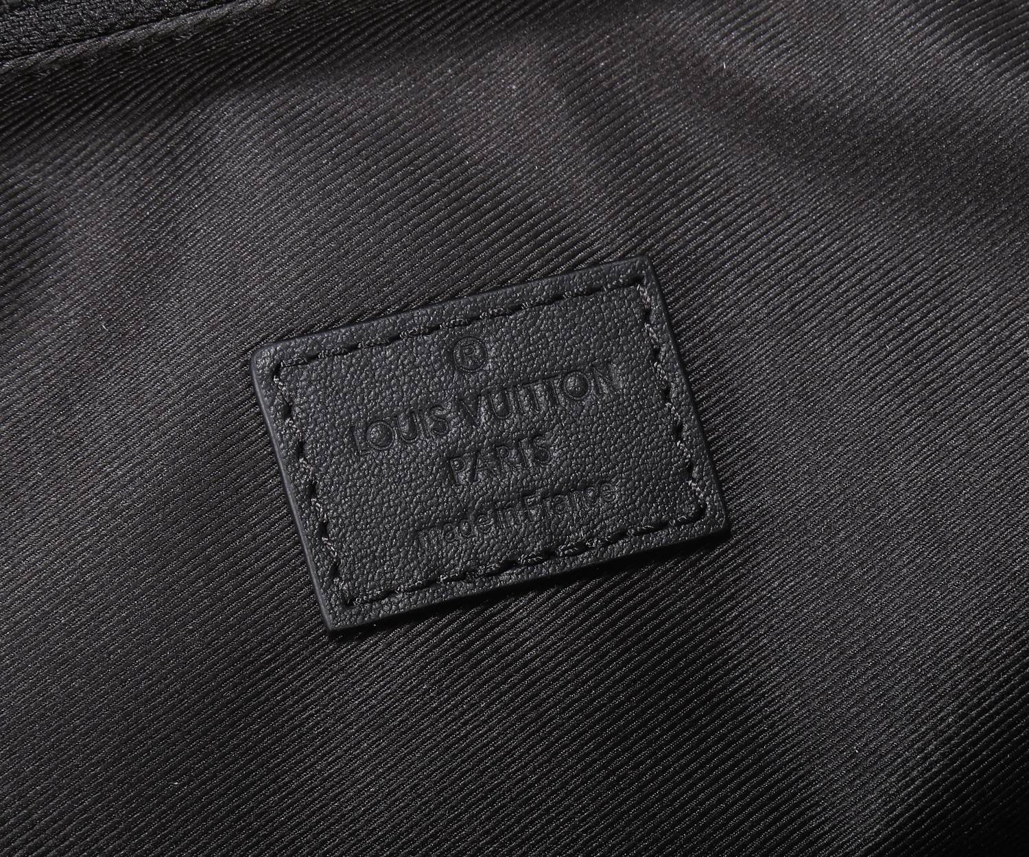 Louis Vuitton logo patch on textured black lining fabric
