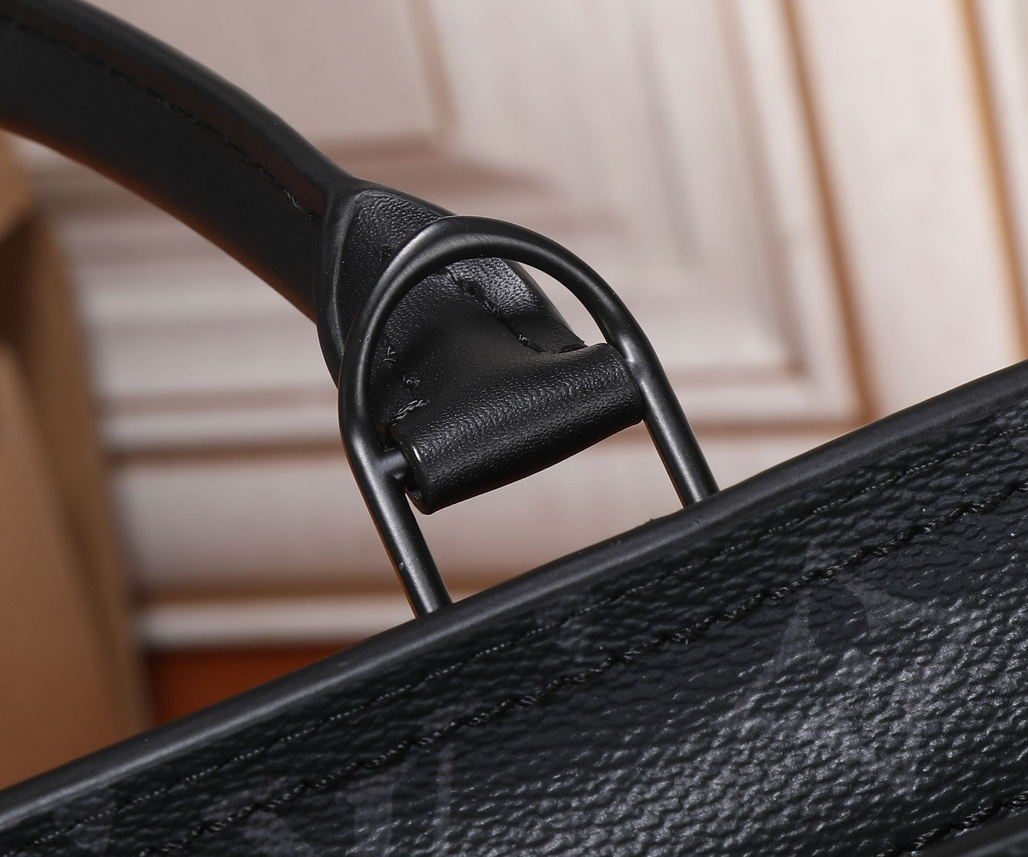 Black Louis Vuitton tote handle with stitched leather loop and metal ring