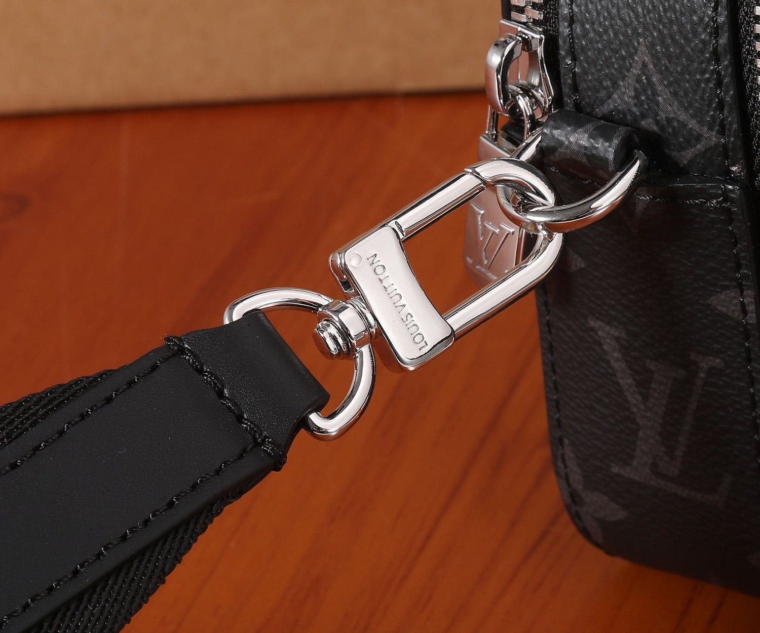 Louis Vuitton crossbody bag with silver lobster clasp and adjustable black strap